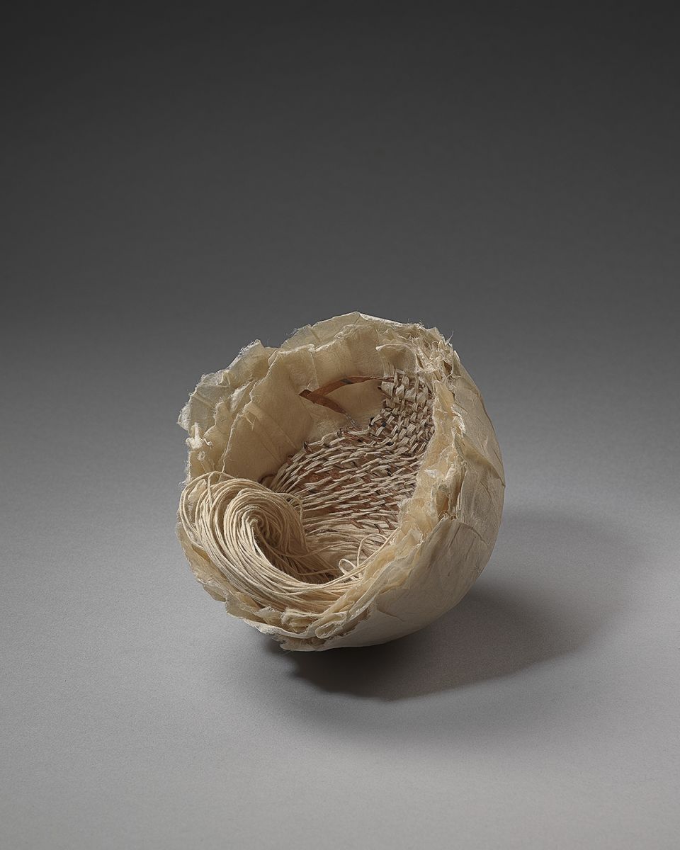 Eleanor Burkett, Mottainai III. Washi paper cast with weaving of persimmon-dyed hand-rolled strips of script and paper warp. Photograph by David Brunetti.